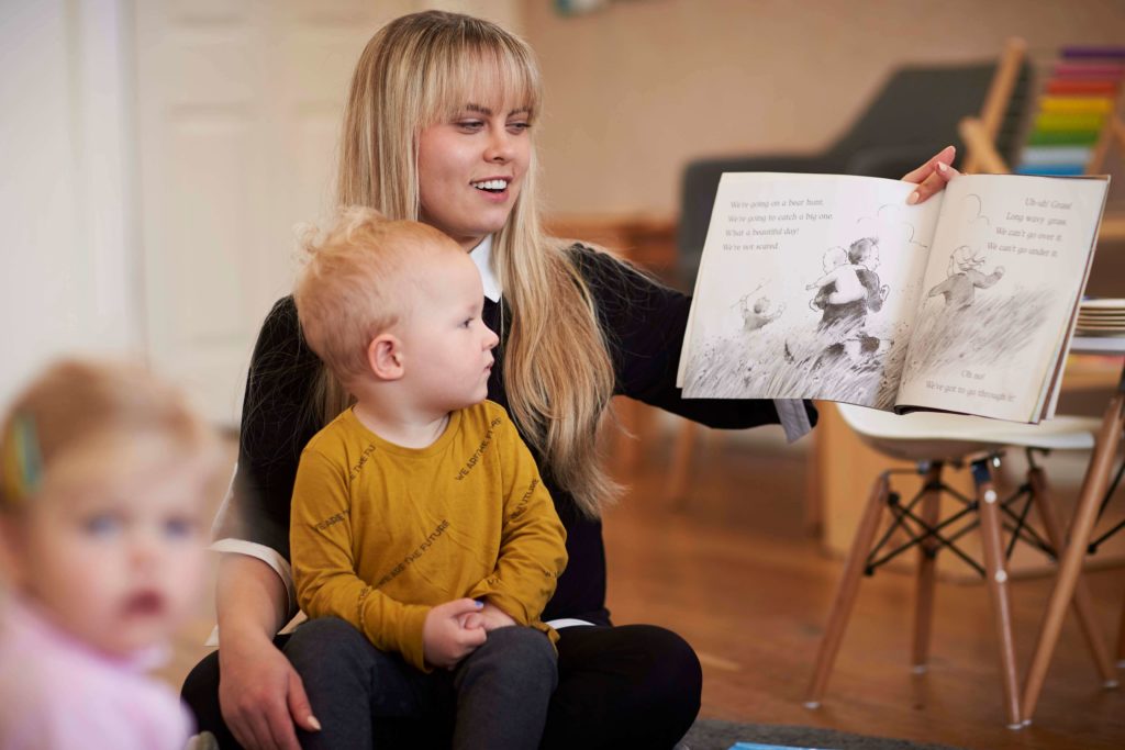 Educator from Only About Children reading a picture book to children 