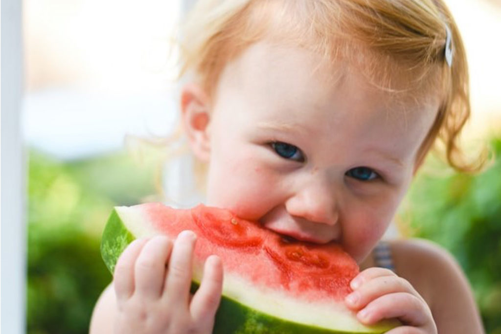 Girl eating a slice of watermelon